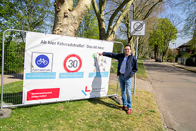 Bürgermeister vor der neuen Beschilderung der Fahrradstraße