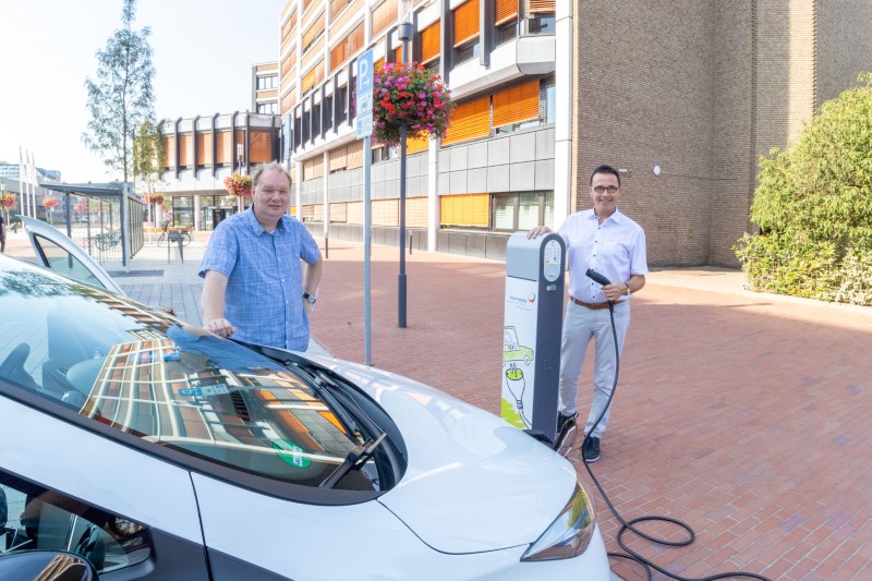 Bürgermeister Prof. Dr. Christoph Landscheidt (rechts) und Kliamschutzmanager Rüdiger Wesseling (links) testen die neue Ladesäule vor dem Rathaus mit dem städtischen E-Auto