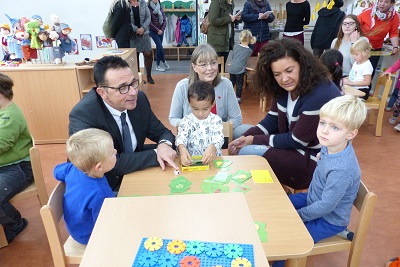 Bürgermeister Christoph Landscheidt spielt Karten mit den KITA-Kindern.